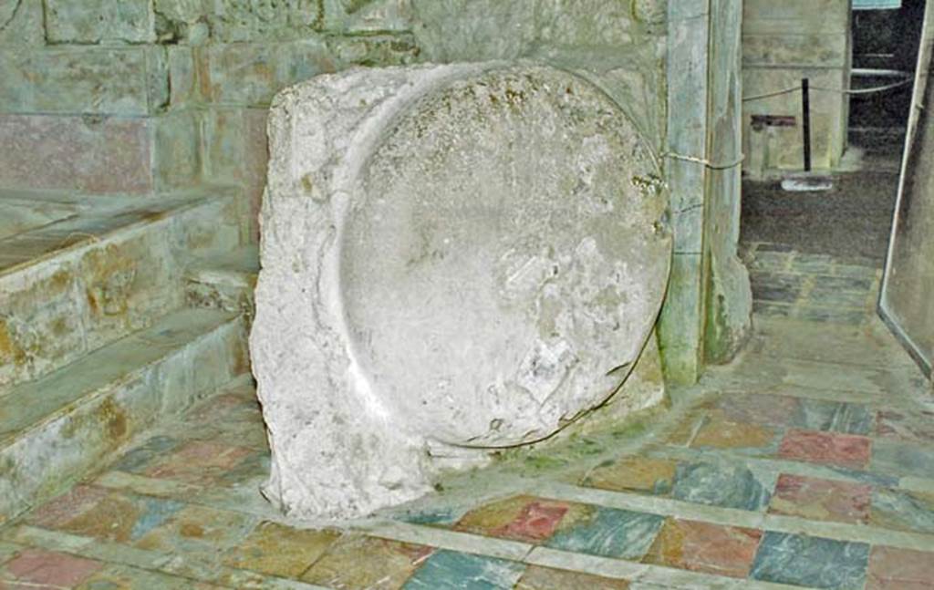 Suburban Baths, Herculaneum. October 2001. Outline form of the shape of the basin set into the volcanic material which entered through the window, violently throwing the basin from its support. Shards of glass appear buried in the cast. Photo courtesy of Peter Woods.